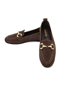Mocassins en suède marron avec quincaillerie en accent doré, des détails cousus et un bout arrondi. Ils présentent un talon bas et une texture douce.
