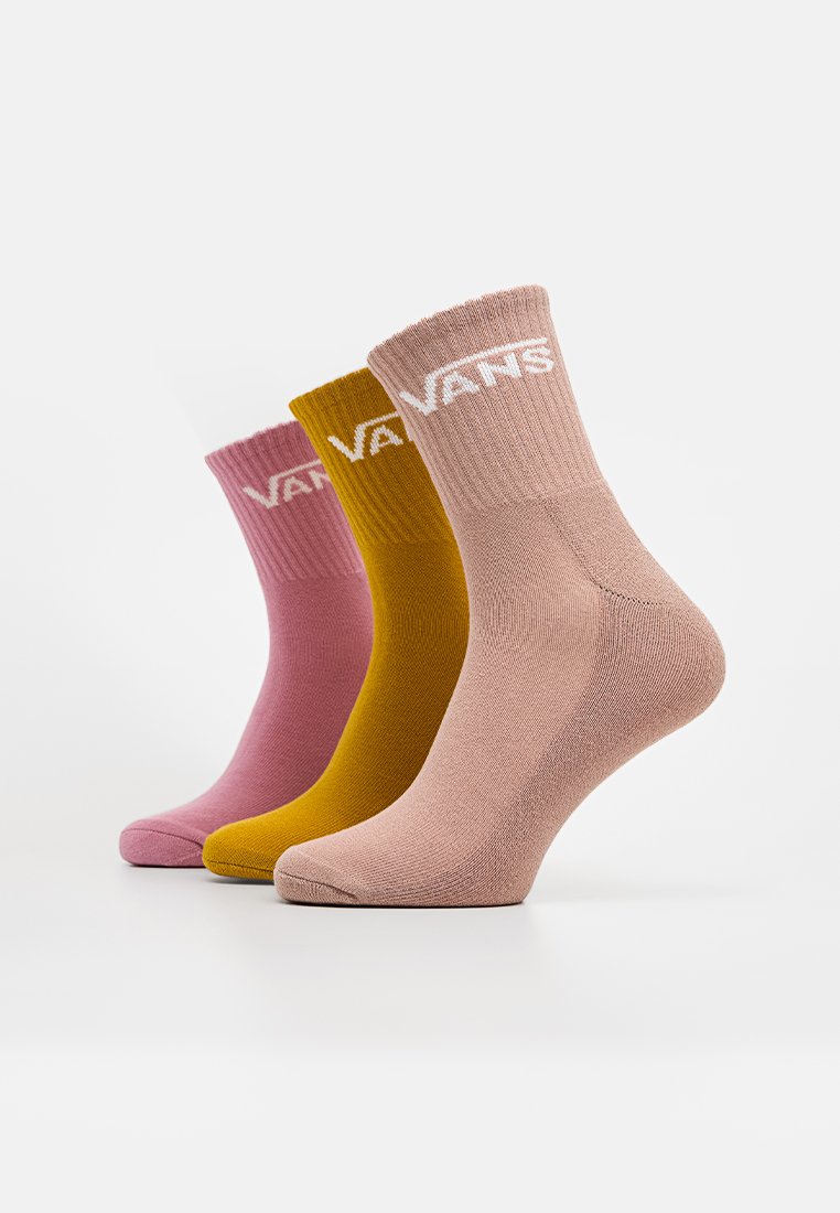 Tre paia di calzini Vans al polpaccio in rosa polveroso, giallo senape e mauve chiaro, esposti in posizione inclinata a destra su uno sfondo bianco.
