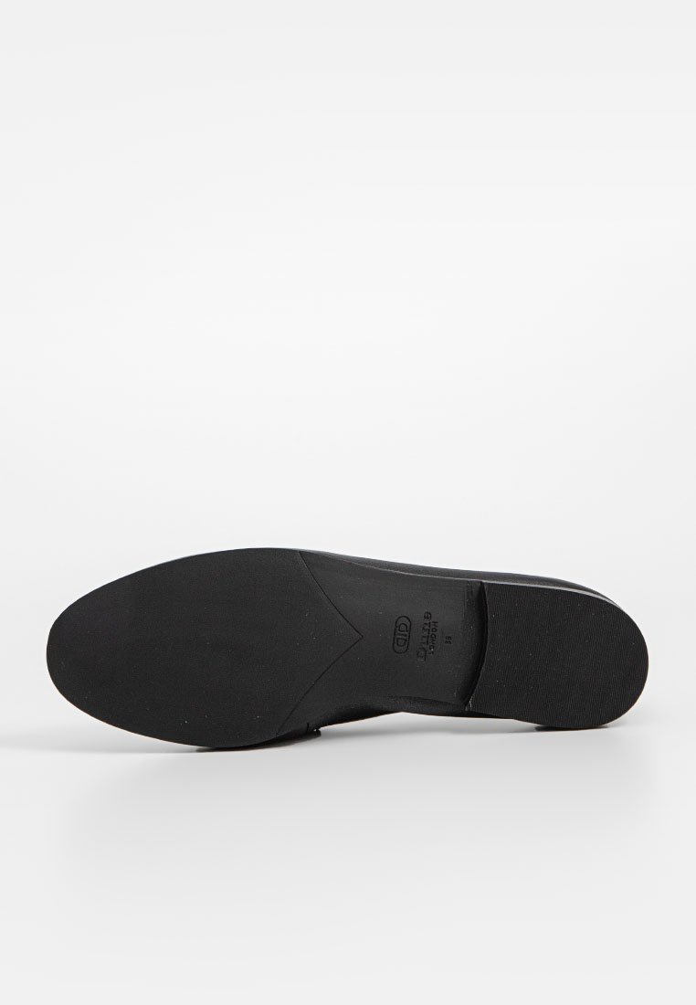 Suela de zapato negra con una textura lisa, forma ligeramente curvada, que presenta una impresión de logotipo y un sutil patrón de adherencia para mejorar el agarre.