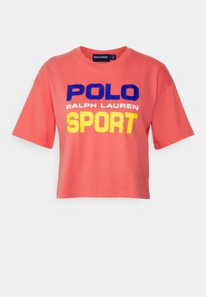 Korallenfarbenes Cropped-T-Shirt mit dem Text "POLO RALPH LAUREN SPORT" in Blau, Weiß und Gelb auf der Vorderseite.