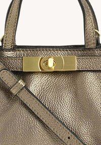 Sac à main texturé métallique avec une poignée supérieure, une bandoulière réglable et un fermoir à tour doré rectangulaire.