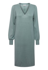 Vestito a maglione in verde tenue, con scollo a V, maniche lunghe a sbuffo e un morbido tessuto lavorato a maglia. I dettagli includono un fiocco al collo.