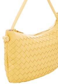 Gelbe gewebte Lederhandtasche mit einem Reißverschluss, einem schmalen Trageriemen und einem strukturierten Muster auf der Oberfläche. Sie besitzt ein rundes Akzentdetail.