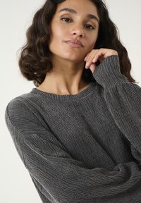 Gray textured knit sweater with a crew neckline and loose-fitting long sleeves, featuring subtle ribbing details throughout the fabric.
