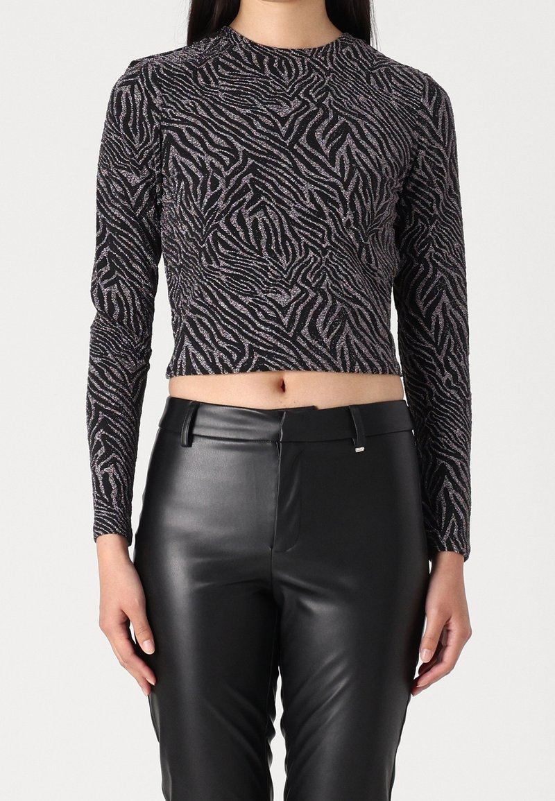 Musta ja hopeinen pitkähihainen paita, jossa on seepranraita-kuvio, valmistettu teksturoidusta, joustavasta kankaasta; lyhyempi malli paljastaa vatsan.