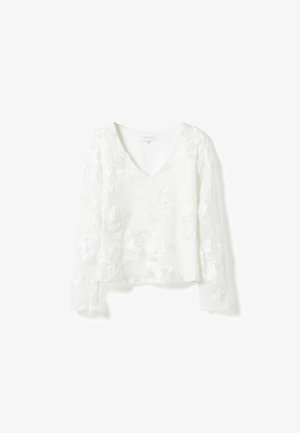 Vit långärmad blus med V-ringning, broderade blommönster och lätt tyg med en något texturerad yta.