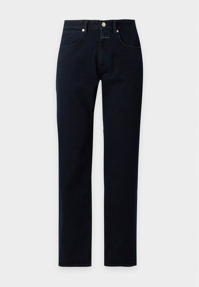 Jean en denim bleu foncé à jambes droites avec poches avant et fermeture par bouton et zip sur un fond clair uni.