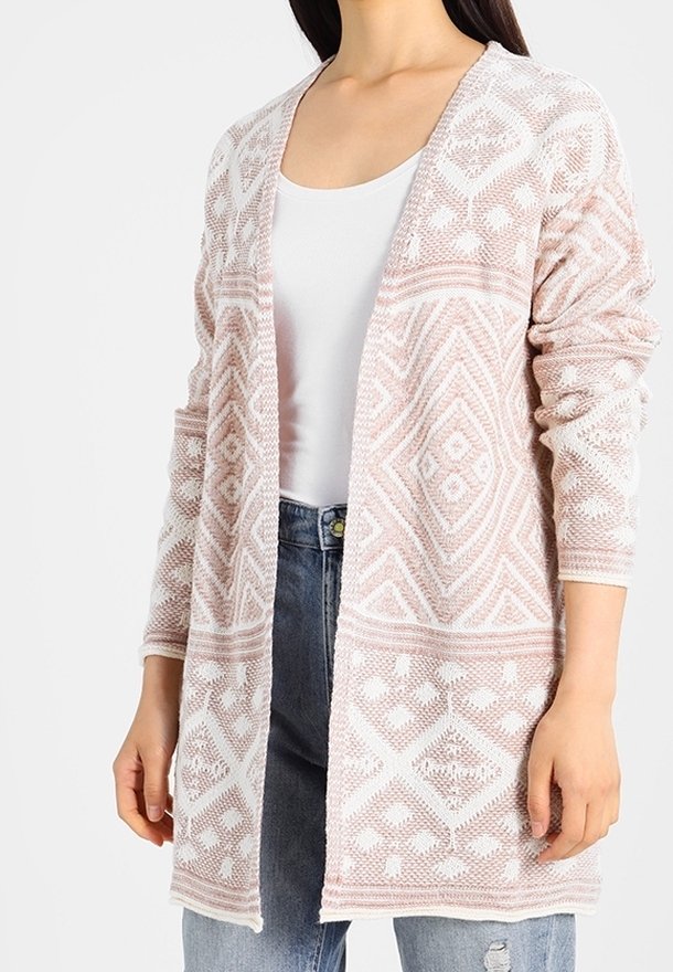 Cardigan ouvert en rose doux, présentant des motifs géométriques blancs délicats. Manches longues, texture tricot légère et coupe décontractée.
