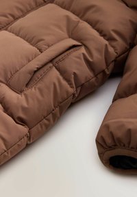 Brązowa kurtka puchowa z przeszyciami, z przednią kieszenią i ściągaczami na mankietach, wykonana z gładkiego, wodoodpornego materiału.
