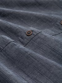 Dark blue fabric with a subtle texture, featuring a fine woven pattern and three brown buttons along the edge. Lightweight and unadorned.