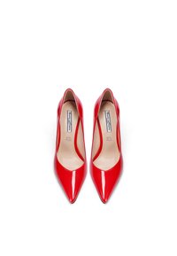 Décolleté in vernice rossa con punta affilata e lati scavati, caratterizzate da una superficie liscia e un'etichetta con la scritta "VERA PELLE" all'interno.