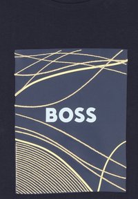 Tamsiai mėlyna marškinė su centrinio dizaino abstrakčiomis geltonomis linijomis ir žodžiu "BOSS", ryškiai išreikštu baltai.