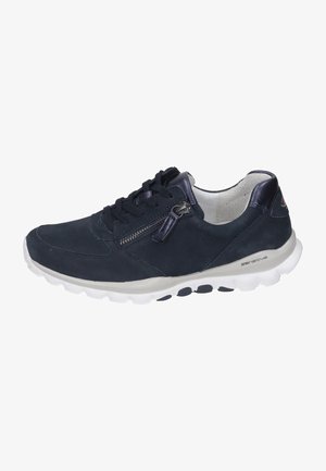 Zapatilla de ante azul marino con un acabado texturizado, que presenta un cierre lateral con cremallera y una suela blanca en contraste con detalles negros. Diseño elegante y funcional.