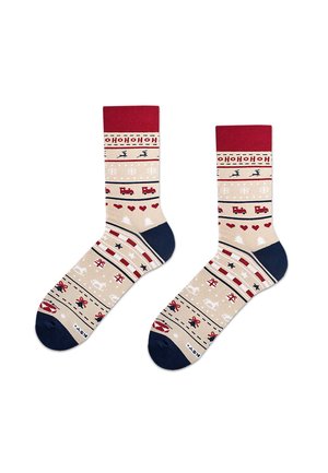 Knit socks with red cuff and navy heel, featuring festive patterns: reindeer, snowflakes, hearts, and trains in beige and red tones.