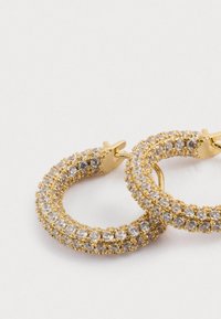 Χρυσά σκουλαρίκια κρίκοι διακοσμημένα με διαυγή και ανοιχτό ροζ κρυστάλλους, διαθέτοντας υφή στην επιφάνεια τους και ασφαλές κλείσιμο τύπου κλιπ.