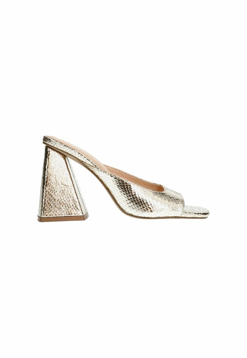 Mules à talon doré métallisé avec un motif texturé en peau de serpent et un talon triangulaire. Conception à bouts ouverts et style à enfiler.