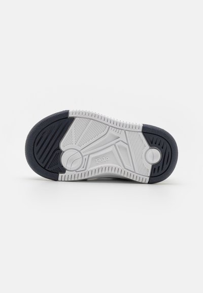 Suola della scarpa con un design in gomma bianca e navy testurizzata, caratterizzata da un motivo circolare vicino al tallone e un logo impresso sul lato.