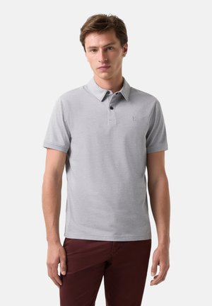 Grå polo shirt med en to-knaps placket, korte ærmer og et broderet logo på brystet, parret med mørkerøde bukser.
