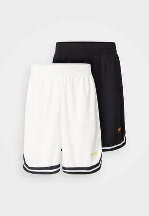 Two pairs of sports shorts: one white with black trim and logo, one black with orange logo, both featuring elastic waistbands.