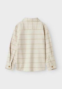 Beige flanellskjorte med rutemønster i lysebrun. Har klassisk krage, lange ermer og knapper ved ermene.