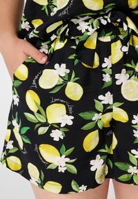 Zwarte shorts met een citroen- en bloemenpatroon. Gemaakt van lichtgewicht stof, met een elastische tailleband en zijzakken.