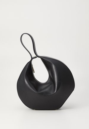 Μαύρη δερμάτινη τσάντα χειρός με μοναδικό, ασύμμετρο σχήμα και καμπύλη λαβή. Λείος υφής, ελάχιστα αξεσουάρ και μεγάλη κεντρική είσοδος.