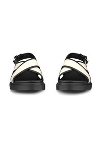 Black and white sandals featuring crossed straps, a thick sole, and an adjustable buckle. Constructed from synthetic materials.