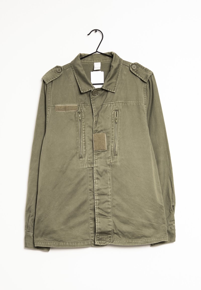 Veste vert olive avec un col, deux poches frontales zippées et des épaulettes. Fabriquée en tissu texturé.