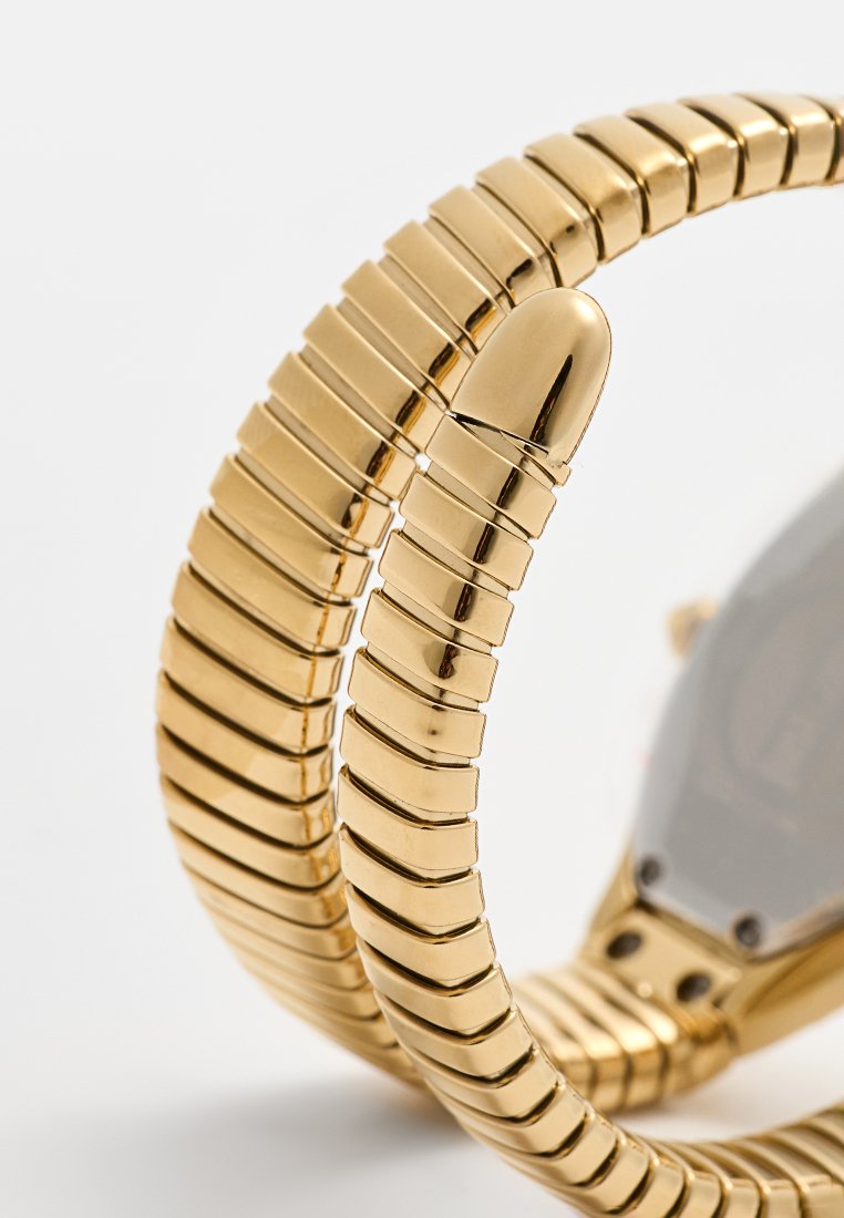 Gouden horloge met een flexibele, gearticuleerde band en een gladde, metalen afwerking. Beschikt over een ronde kast met een grijze wijzerplaat en minimale hardwaredetails.