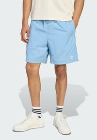 Light blue shorts made of lightweight material, featuring an elastic waistband and side pockets. White logo accent on the leg.