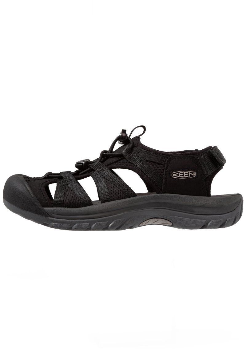 Black sandal with mesh upper, elastic laces, and rubber sole. Features adjustable heel strap and cut-out design for breathability.