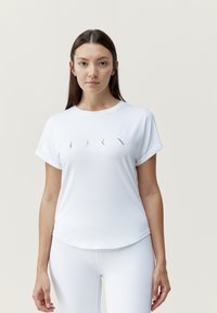 Witte sportieve shirt met korte mouwen en een ronde halslijn, gemaakt van een soepele stof. Heeft een subtiele design detail aan de voorkant.