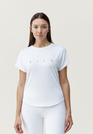 Camiseta atlética blanca de manga corta con cuello redondo y una textura suave. Presenta un detalle de diseño sutil en la parte frontal.