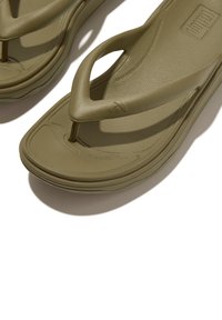 Olijfgroene slippers met een gestructureerde zool, voorzien van een Y-vormig bandontwerp, een gevoerde voetbed en een minimale merkdetail.