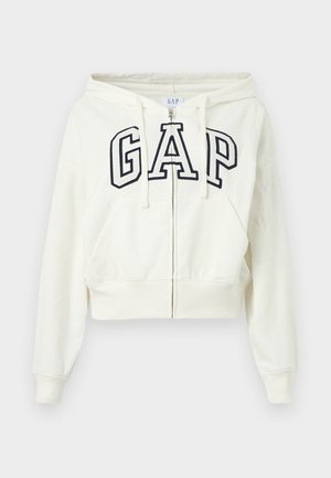 Hvit hettejakke med glidelås, frontlommer og svart omrisset "GAP"-logo over brystet, med snor på hetten og ribbede mansjetter.