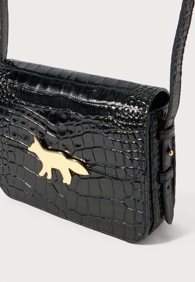 Μαύρο τσάντα ώμου από δέρμα με υφή κροκοδείλου, με ρυθμιζόμενο λουράκι και χρυσό κούμπωμα σε σχήμα αλεπούς στο μπροστινό καπάκι.