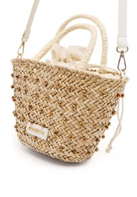Bolso de paja tejido de forma redonda, adornado con lentejuelas doradas, con dos asas, un cierre de cordón y una correa blanca desmontable.