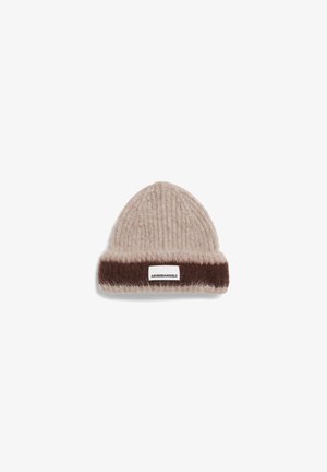 Beige gebreide beanie met een donkerbruine omgeslagen rand, voorzien van een wit etiket met de tekst "ARMEDANGELS". Zachte textuur en ronde vorm.