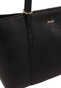 Zwarte leren totebag met een gestructureerd oppervlak, gouden hardware accentuering en een eenvoudig ontwerp; bevat een klein logo aan de voorkant.