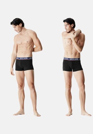 Caleçons boxers noirs avec un waistband élastique blanc et marine arborant le logo "pierre cardin" ; modèle montré sous deux angles, mettant en valeur la coupe et le style.
