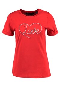 Camiseta de algodón rojo con mangas cortas y cuello redondo. Presenta un corazón cosido en blanco con la palabra "amor" en su interior.