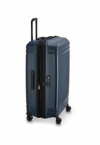 Maleta dura de color navy con surcos verticales, asa retráctil, cierres dobles, cerradura TSA y cuatro ruedas giratorias negras.