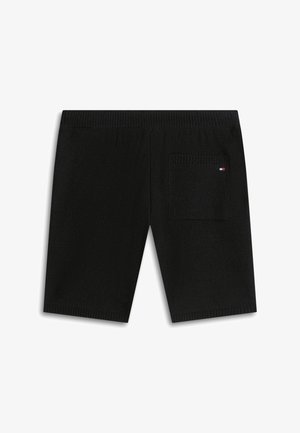 Shorts en maille noire avec taille élastique et une seule poche arrière ornée d'un petit logo rectangulaire rouge, blanc et bleu.