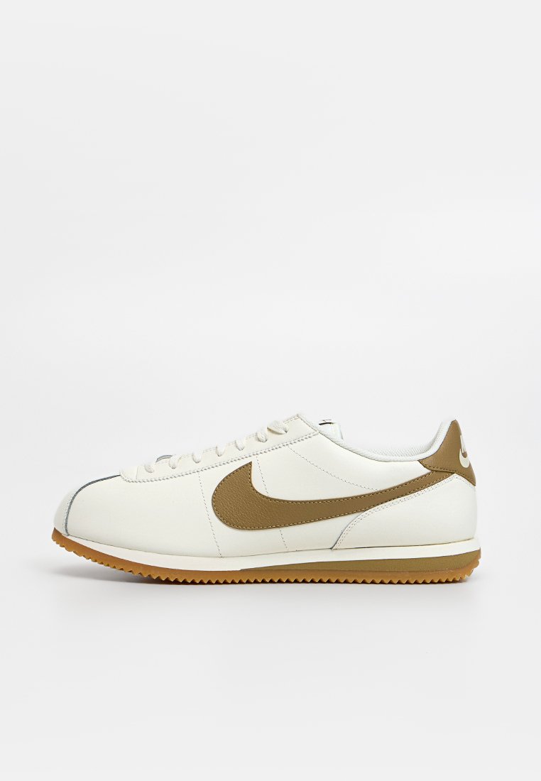 Weiße Leder-Sneaker mit braunen Akzenten, runder Spitze, Schnürdesign und einer strukturierten Gummi-Sohle. Nike-Logo an der Seite.