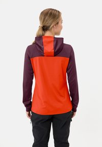 Kapuzenshirt mit roten und dunkelpurpurnen Einsätzen, langen Ärmeln und einer glatten Textur. Reißverschluss-Taschen sind aus diesem Winkel nicht sichtbar.
