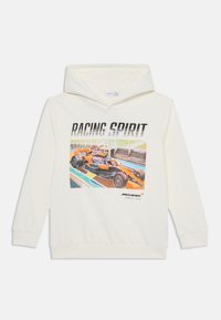 Valge kapuutsiga sviiter, millel on värviline graafika sõidukist ja tekst "RACING SPIRIT" ning "McLaren Formula 1 Team."