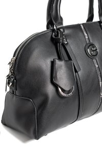 Czarna skórzana torebka o zaokrąglonym kształcie, z metalowymi elementami w kolorze srebrnym, zamykana na zamek błyskawiczny oraz z bocznym detalem w postaci metki. Charakteryzuje się gładką fakturą i kontrastującymi akcentami.