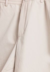 Beige shorts van een katoenen mixstof. Voorzien van een elastische tailleband, platte naden en zijzakken met een gladde textuur.