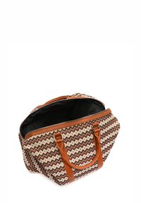 Woven tote bag with a zigzag pattern in red, cream, and brown. Brown faux leather handles and zipper closure. Spacious black interior.