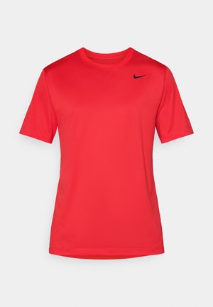 T-shirt de sport rouge à manches courtes et col rond, avec un petit logo noir de Nike en forme de swoosh sur le haut à gauche de la poitrine.